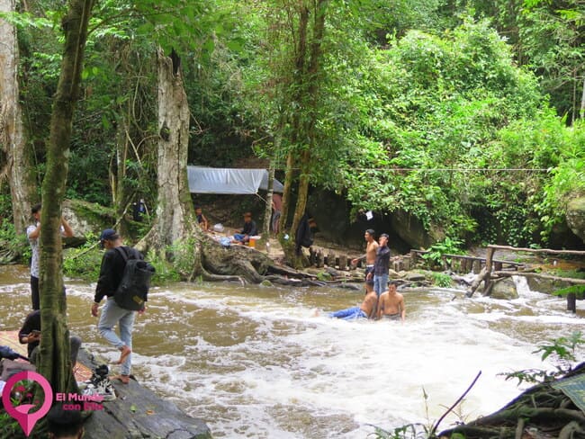 Gente disfrutando de un baño en las aguas frías de la cascada en Phnom Kulen Visitantes sumergiéndose en las aguas naturales de la cascada de Phnom Kulen